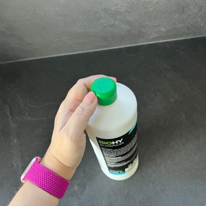 Eine Hand hält den Deckel des Biohy-Klarspülers fest