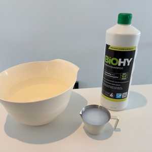 Biohy-Teppich-Shampoo, Behälter mit dem Shampoo und Schale mit Wasser auf einer Ablage.