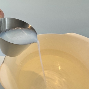 Der Reiniger von Biohy wird in eine Schale mit Wasser gegossen.