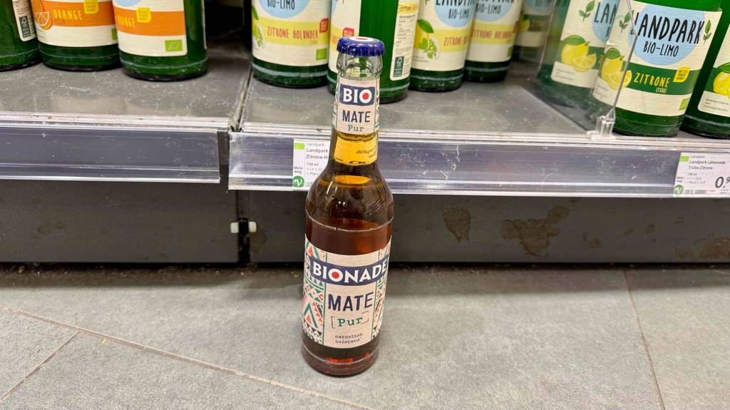 Getestet: Bio-Mate Tee in der Flasche steht vor einem Regal mit Getränkeflaschen.