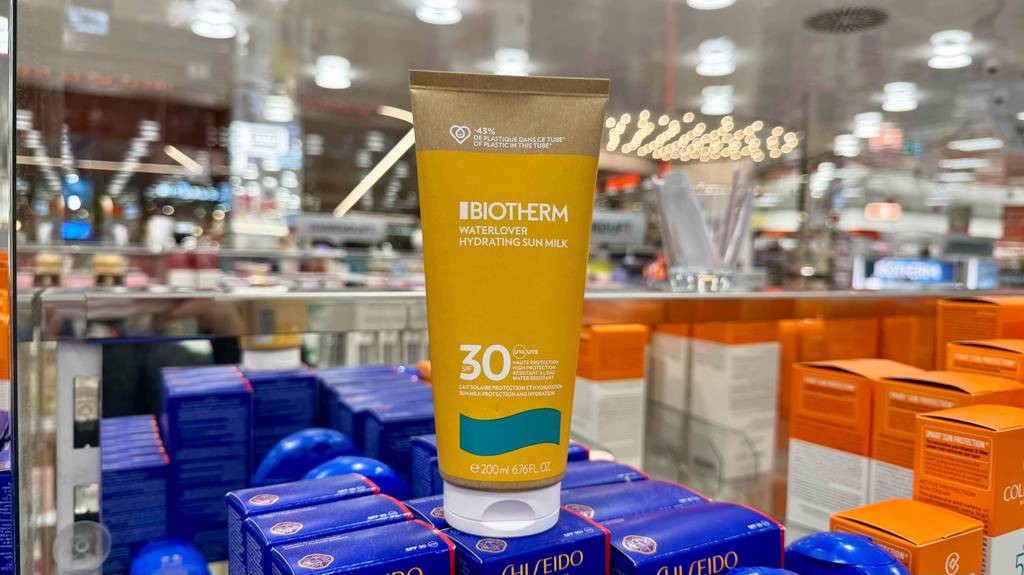 Eine Tube Biotherm-Sonnencreme steht zum testen auf blauen Verpackungen.