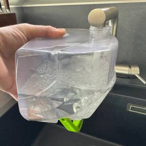 Eine Hand füllt den Wasserbehälter des Bissell 15585 SpotClean Pet Pro Portable auf