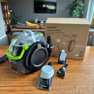 Der Bissell 15585 SpotClean Pet Pro Portable steht zusammen mit dem Karton und den Aufsätzen auf einem Tisch