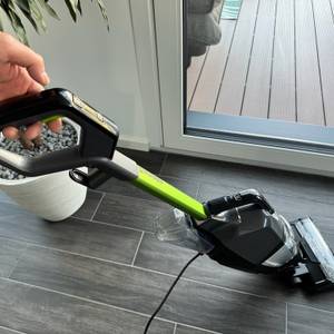 Eine Hand hält den Bissell Crosswave Hydrosteam PET am Griff fest