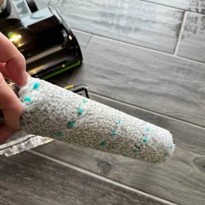 Eine Hand hält die Rolle des Bissell Crosswave Hydrosteam PET fest