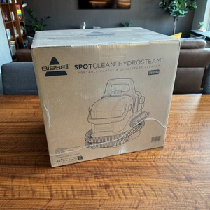 Der Karton des Bissell SpotClean 3689N steht auf einem Tisch