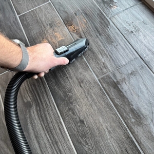 Eine Hand reinigt einen Fliesenboden mithilfe des Bissell SpotClean 3689N