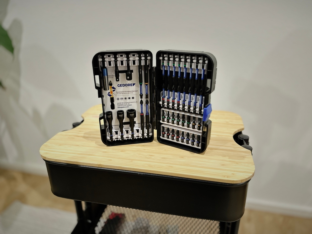 Das Bitset von Gedore steht aufgeklappt auf einer hölzernen Platte.