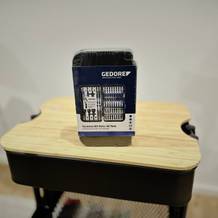 Das Bitset von Geodore steht auf einer hölzernen Platte vor einem weißen Hintergrund.