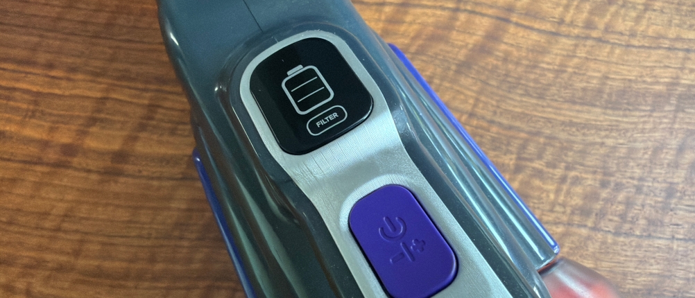 Ein großer blauer Knopf zum Bedienen vom Black+Decker BHHV520BFP