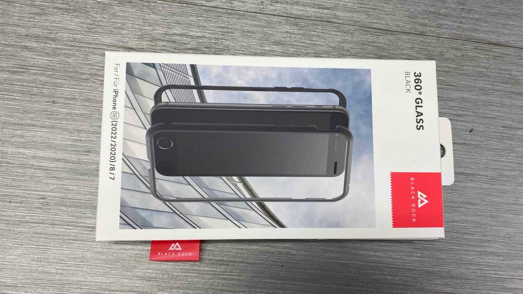 iPhone-SE-Panzerglas-Test: eine Verpackung Black Rock mit einem 360 Grad Glas inklusive schwarzem Rand liegt auf einer grauen Oberfläche.