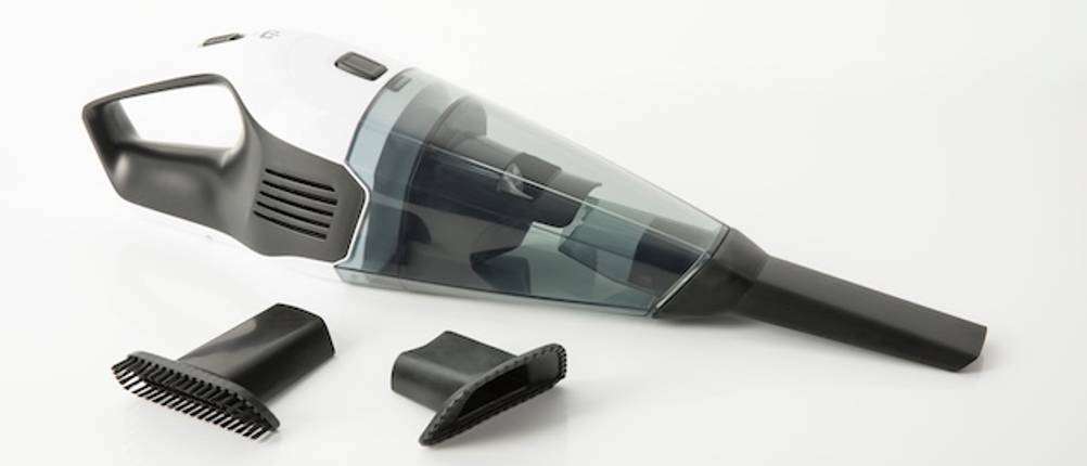Black-und-Decker-Akku-Staubsauger-Test: Nahaufnahme eines Akku-Handstaubsaugers mit Zubehör vor weißem Hintergrund.