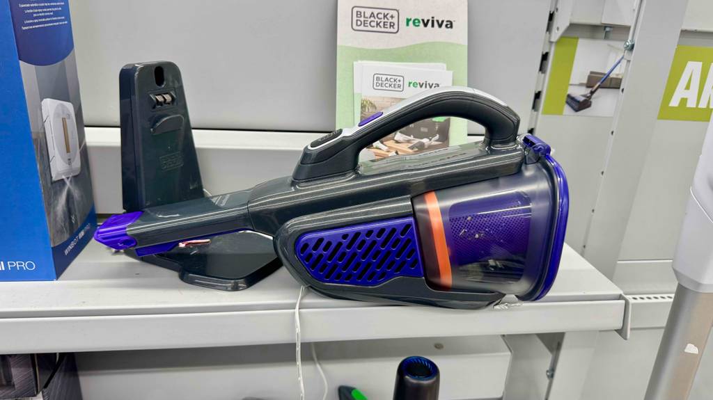 Der batteriebetriebene Black-und-Decker-Handstaubsauger im Test liegt auf einem Ausstellungsregal neben seiner Ladestation. 
