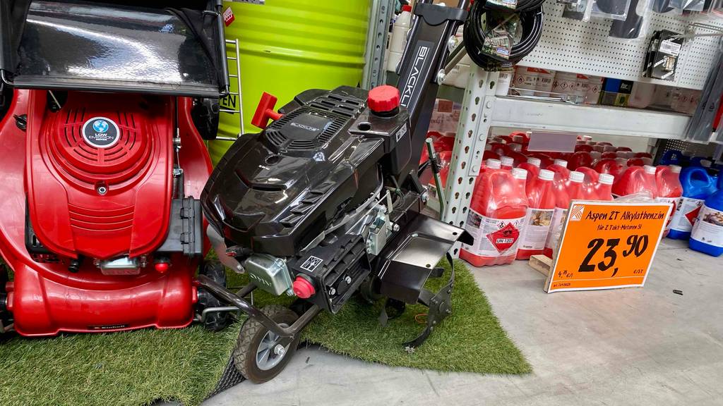 Motorhacken-Test: Detailansicht auf ein schwarzes Modell der Marke Blackline, das in einem Ausstellungsbereich neben anderen Garten-Utensilien steht.