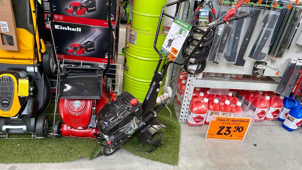 Motorhacken-Test: Gesamtansicht eines schwarzen Modells der Marke Blackline, das mit einem Doppel-Handgriff versehen und in einem Geschäft neben Garten-Utensilien ausgestellt ist.
