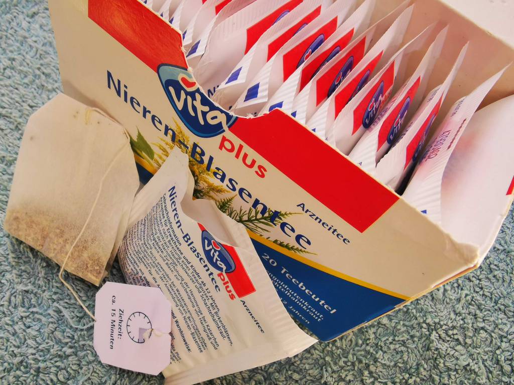 Ein Beutel lehnt neben der Einzelverpackung an eine Kartonbox Blasen-und-Nierentee zum testen.
