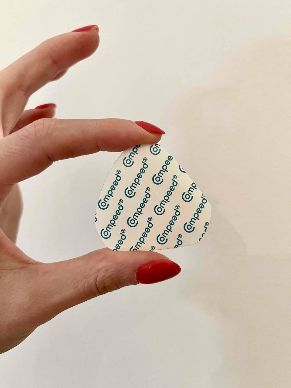 Getestet: Eine Hand hält ein Blasenpflaster mit der Rückseite nach vorne.