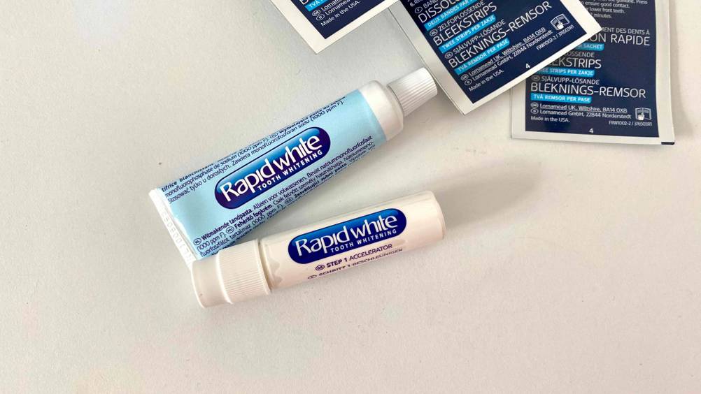 Bleaching-Strips getestet: Eine Tube und ein Fläschchen auf einer hellen Fläche.