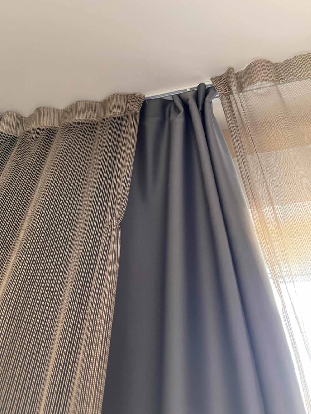 Nahaufnahme der Aufhängung eines getesteten blickdichten Vorhangs vor einem Fenster