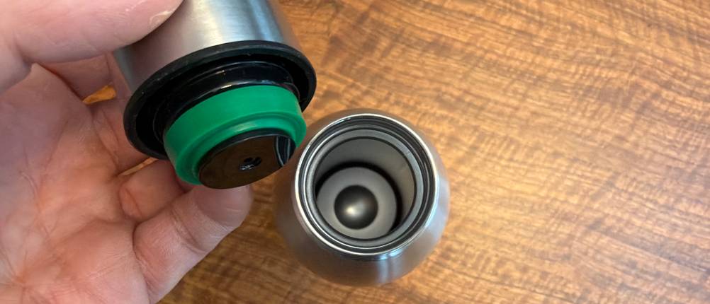 Eine Hand hält den Deckel der Blockhütte BH0014 fest