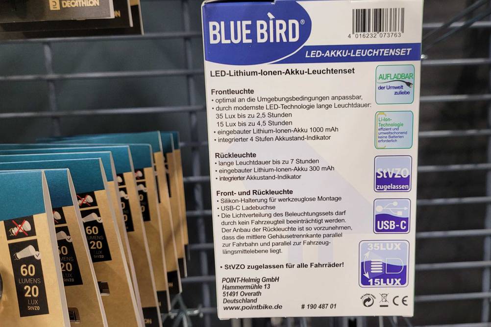 Fahrradlampen im Test: Nahaufnahme einer rückwärtigen Blue Bird LED-AKKU-Leuchtenset Verpackung an einem Verkaufsregal.