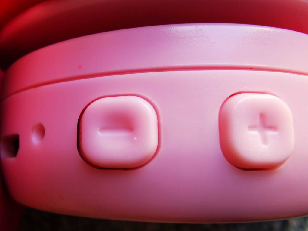 Detailansicht der Lautstärkeregler an einem pinkfarbenen getesteten Bluetooth-Kopfhörer bis 50 Euro.