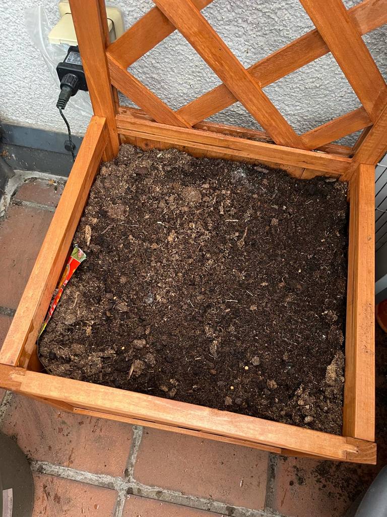 Blumenkästen mit Rankgitter-Test: Detailansicht des Behälters aus Holz voller Erde.