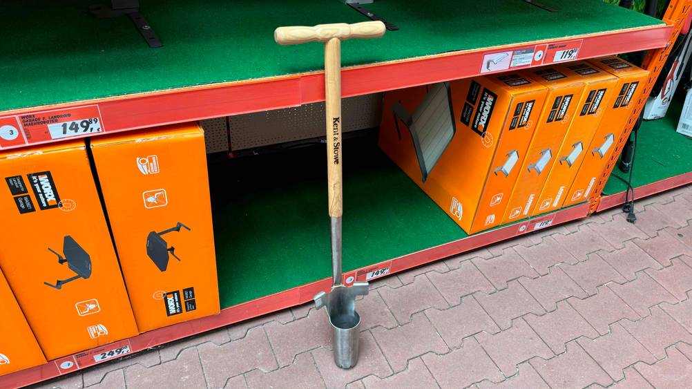 Ein getesteter Blumenzwiebelpflanzer an einem Verkaufsregal lehnend.