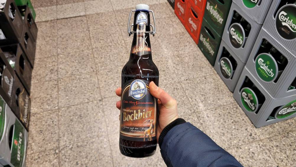Eine Hand hält eine Flasche des getesteten Bockbiers hoch.