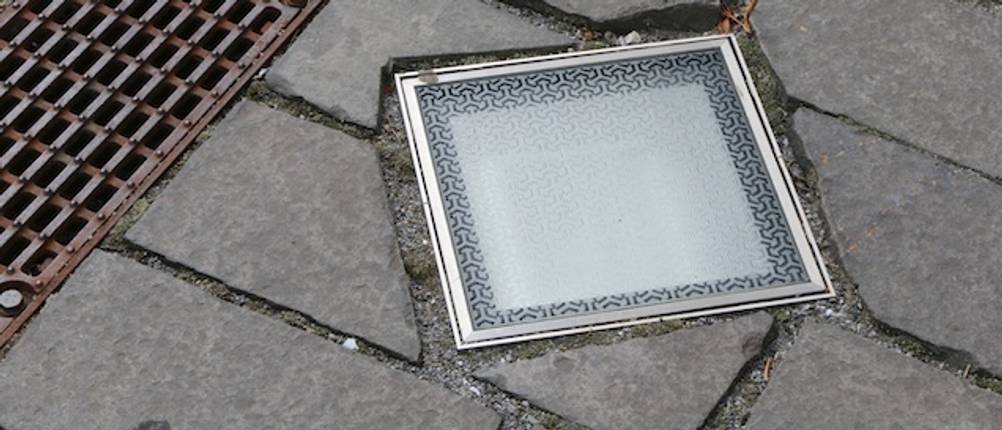 Quadratischer Bodeneinbaustrahler auf einem Fußweg getestet.