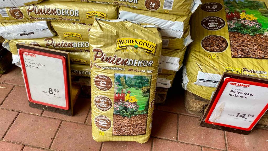 Im Test: Ein Sack Pinienmulch steht vor einem Stapel Säcke zwischen zwei Preisschildern.
