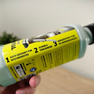 Eine Hand hält den Bodenreiniger von Kärcher seitlich.