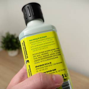 Eine Hand hält den Bodenreiniger von Kärcher.