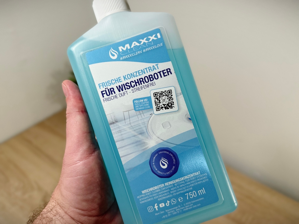 Eine Hand hält den Bodenreiniger von MAxxiclean.