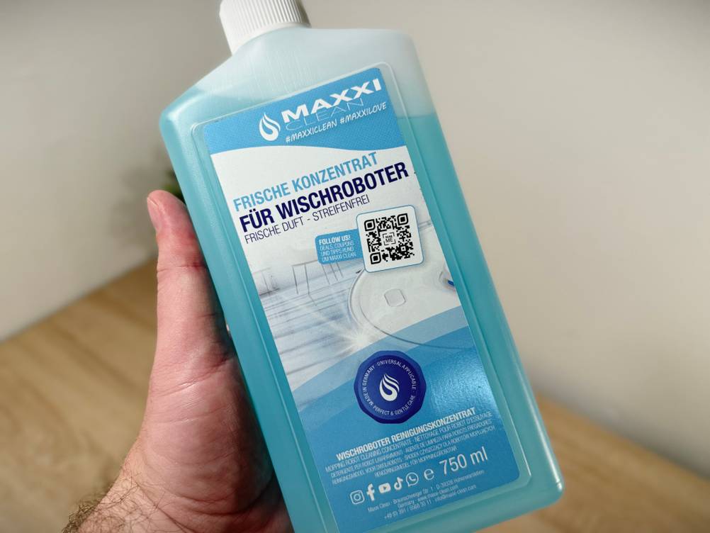 Eine Hand hält den Bodenreiniger von MAxxiclean.