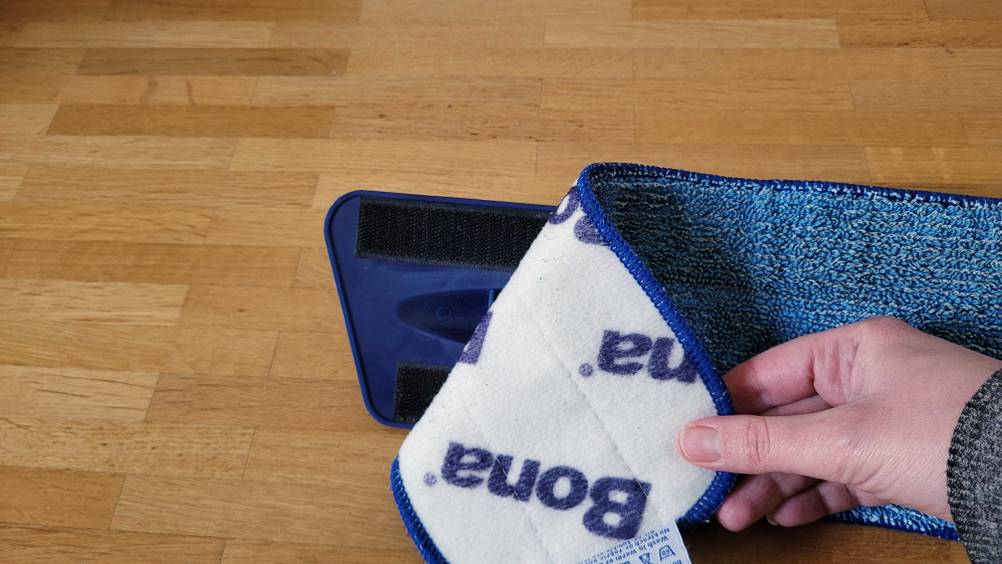 Bodenwischer getestet: Eine Hand zieht das Pad vom Wischer ab.