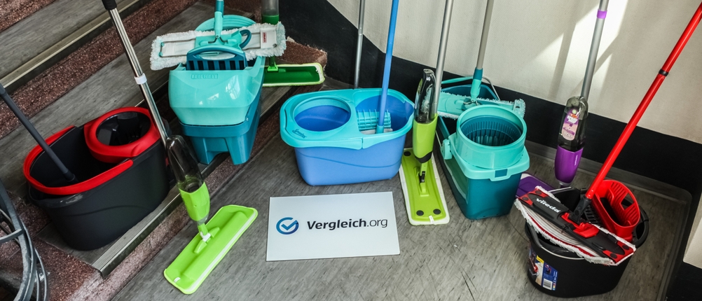 Verschiedene Bodenwischer auf dem Boden nebeneinander mit Eimern.