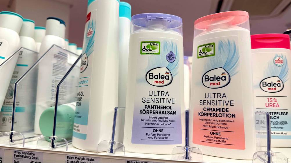 Mehrere Flaschen der getesteten Bodylotion ohne Parfüm in einem Verkaufsregal.