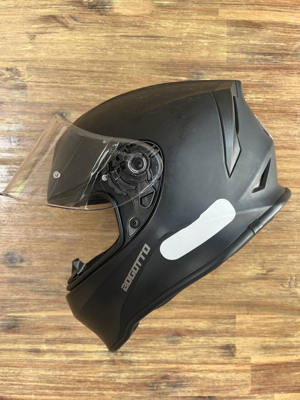 Seitliche Ansicht eines getesteten Kinder-Motorradhelms in Schwarz mit geöffnetem Visier.
