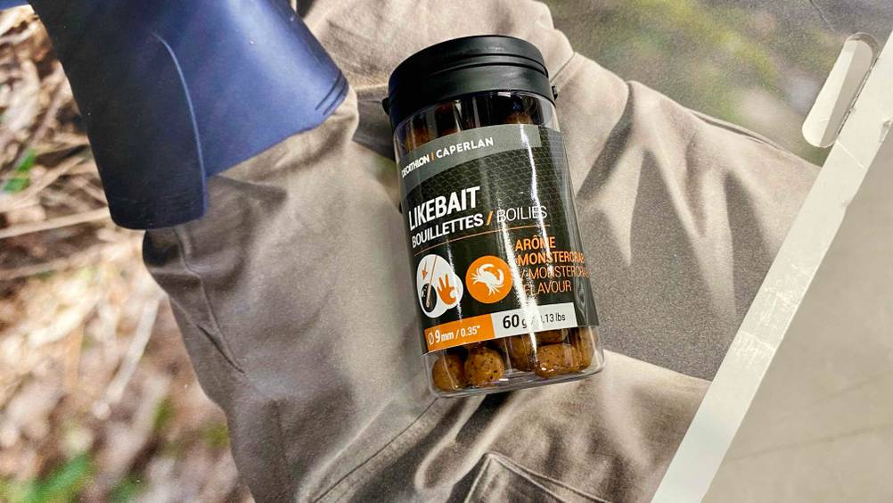 Eine Dose mit Boilies im Test auf einem beduckten Karton.