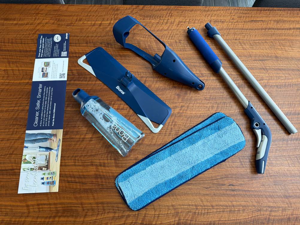 Der Lieferumfang vom Bona-Bodenwischer liegt auf einem Tisch.