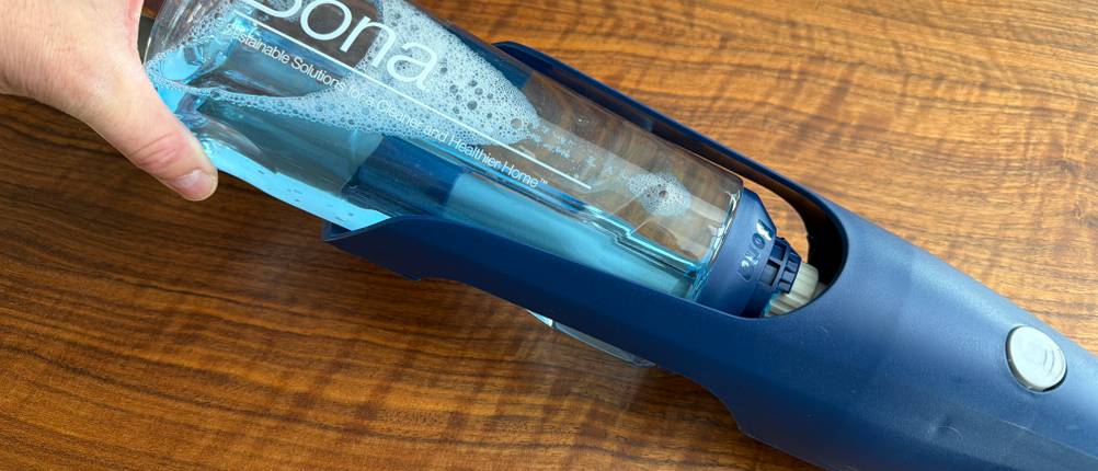 Ein Behälter mit Reinigungsflüssigkeit wird in den Bona-Bodenwischer eingelegt.