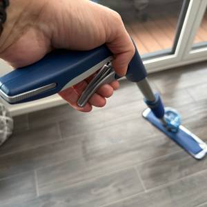 Eine Hand zieht an einem Hebel am Griff vom Bona-Bodenwischer.