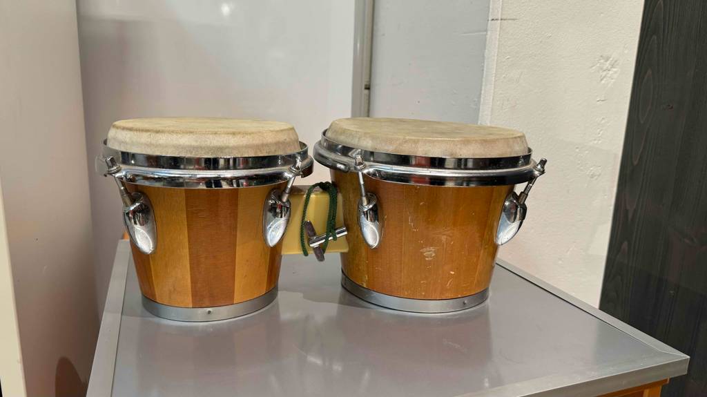 Bongos im Test von der Seite auf einer grauen Fläche stehend.