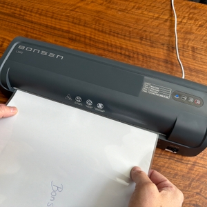 Zwei Hände schieben ein Blatt zum Laminieren in das Bonsen L3103