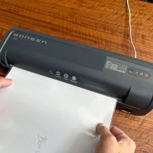 Zwei Hände schieben ein Blatt zum Laminieren in das Bonsen L3103