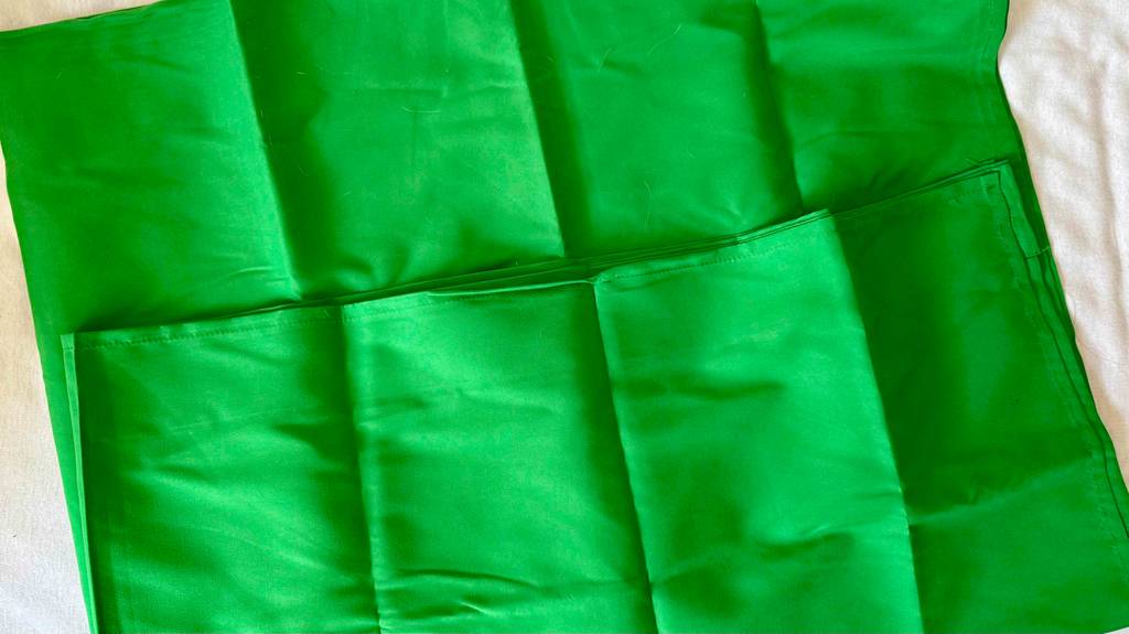 Ein getesteter Green Screen ist halb zusammengefaltet.