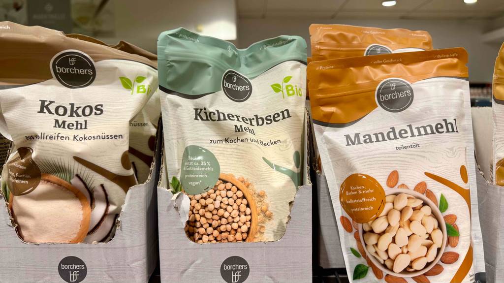 Mehrere wiederverschließbare Beutel mit getestetem Kichererbsenmehl und anderen Mehlsorten befinden sich nebeneinander auf einem Verkaufsregal.