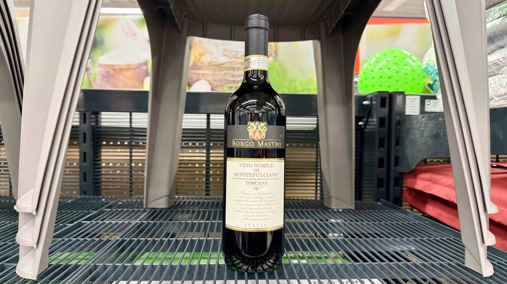 Frontansicht im Detail einer Flasche getesteter Montepulciano-Wein, die in einem Gitterregal steht.