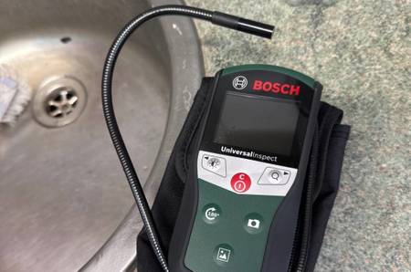 Endoskop-Kamera im Test: Modell 603687000 von Bosch auf einer Waschtisch-Ablage, mit Fokus auf den beweglichen Schlauch inklusive Kamera.